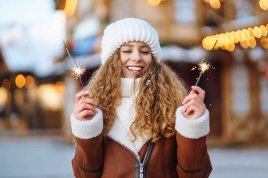 Mutlu kadın kış Noel pazarında eğleniyor. Genç bir turist güneşli bir kış gününde Yeni Yıl atmosferinin tadını çıkarıyor. Tatil kavramı, rahatlama..