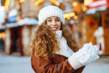Mutlu kadın kış Noel pazarında eğleniyor. Genç bir turist güneşli bir kış gününde Yeni Yıl atmosferinin tadını çıkarıyor. Tatil kavramı, rahatlama..