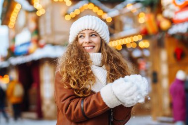 Mutlu kadın kış Noel pazarında eğleniyor. Genç bir turist güneşli bir kış gününde Yeni Yıl atmosferinin tadını çıkarıyor. Tatil kavramı, rahatlama..