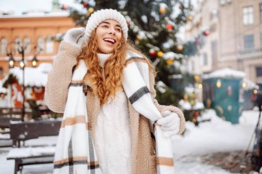 Noel tatilinde şehir caddesinde güzel bir kadın. Eşarplı genç bir turist Noel pazarında yürüyor. Noel konsepti, tatiller.