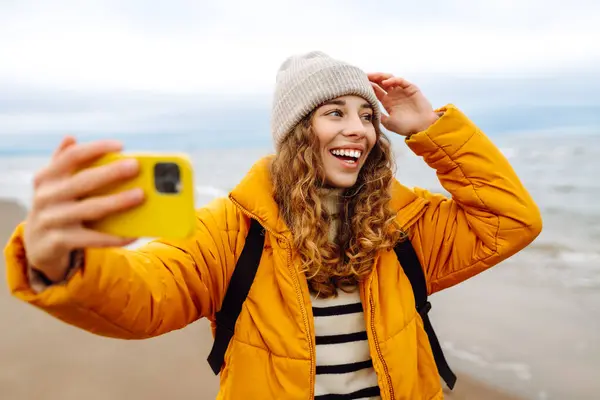 Potret Seorang Wanita Bahagia Dengan Telepon Pantai Dia Mengenakan Jaket — Stok Foto