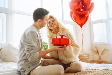 Genç adam evde kız arkadaşına hediye veriyor. Evde Sevgililer Günü 'nü kutlayan güzel genç bir çift. Romantik bir gün..