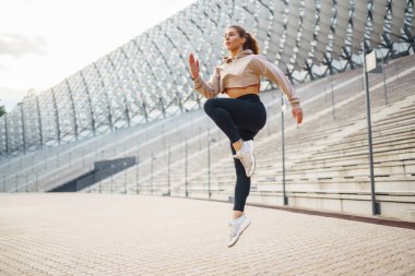 Açık havada egzersiz yapan zinde bir kadın. Sağlıklı genç bayan sporcu spor yapıyor. Aktif yaşam tarzı konsepti, spor.