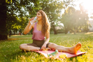 Parkta egzersiz yaparken yoga yapan genç bir kadın. Fitness. Etkin yaşam biçimi.