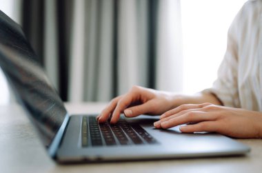 Dizüstü bilgisayarda klavye üzerinde çalışan ellerin yakın çekimi. Kadın müşterinin e-postasına cevap veriyor, alıcı çevrimiçi mağaza hizmetlerini kullanarak internetten satın alıyor. İnternet ve modern kablosuz teknolojileri kullanma kavramı