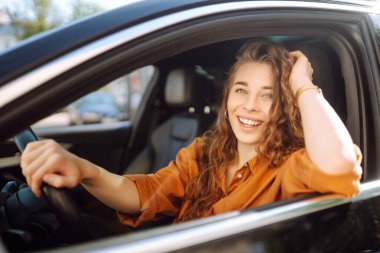 Mutlu bir kadın araba sürüyor ve gülümsüyor. Otomobil yolculuğu. Aynı arabayı paylaşıyoruz. Yaşam tarzı kavramı.