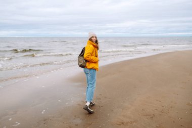 Deniz kenarında yürüyen mutlu bir turist. Yaşam tarzı, seyahat, turizm, doğa, aktif yaşam.