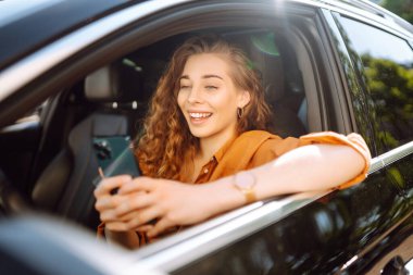 Telefonlu bir arabada güzel bir kadın sürücü. Şehirdeki park ve seyir masraflarını ödüyorum. Boş zaman, seyahat, teknoloji, meşguliyet.