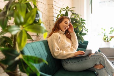 Kafede dizüstü bilgisayarla oturan mutlu kadın. Eğitim, iş, alışveriş, blog veya serbest çalışma kavramı.