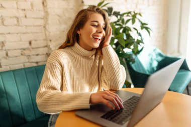 Kafede dizüstü bilgisayarla oturan mutlu kadın. Eğitim, iş, alışveriş, blog veya serbest çalışma kavramı.