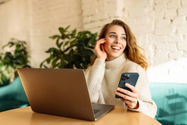 Kafede dizüstü bilgisayarla oturan mutlu kadın. Eğitim, iş, alışveriş, blog veya serbest çalışma kavramı.