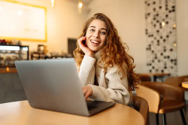 Happy woman sitting on cafe with laptop. Concept for education, business, shopping, blog or freelance.