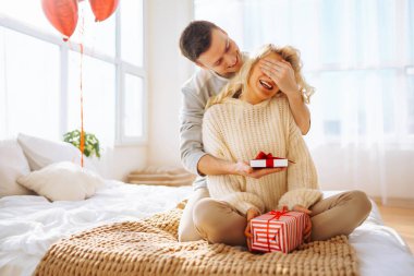 Evde Sevgililer Günü 'nü kutlayan güzel genç bir çift. Hediye değişimi. Birlikte romantik bir gün..