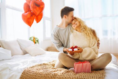 Evde Sevgililer Günü 'nü kutlayan güzel genç bir çift. Hediye değişimi. Birlikte romantik bir gün..