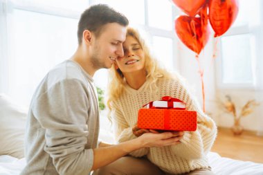 Evde Sevgililer Günü 'nü kutlayan güzel genç bir çift. Hediye değişimi. Birlikte romantik bir gün..