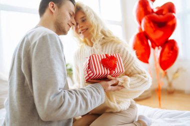 Evde Sevgililer Günü 'nü kutlayan güzel genç bir çift. Hediye değişimi. Birlikte romantik bir gün..