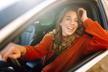 Arabada oturup pencereden bakan güzel bir kadın. Araba yolculuğu, yaşam tarzı, taşıma konsepti..