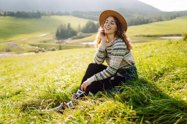 Yeşil çimen vadisinde yürüyen bir kadın büyük dağlarda. Yürüyüşçü dinleniyor. Güzel Ulusal Park. Moda, güzellik, turizm, dinlenme konsepti.