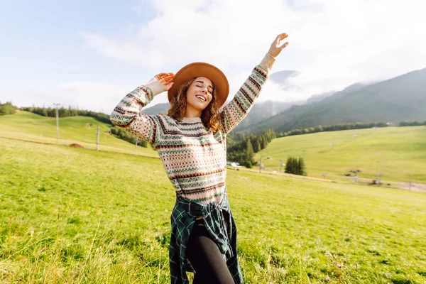 Yeşil çimen vadisinde yürüyen bir kadın büyük dağlarda. Yürüyüşçü dinleniyor. Güzel Ulusal Park. Moda, güzellik, turizm, dinlenme konsepti.