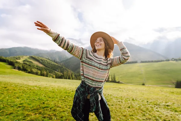 Yeşil çimen vadisinde yürüyen bir kadın büyük dağlarda. Yürüyüşçü dinleniyor. Güzel Ulusal Park. Moda, güzellik, turizm, dinlenme konsepti.