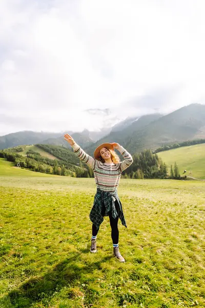 Yeşil çimen vadisinde yürüyen bir kadın büyük dağlarda. Yürüyüşçü dinleniyor. Güzel Ulusal Park. Moda, güzellik, turizm, dinlenme konsepti.