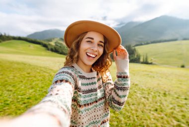 Doğada selfie çeken güzel bir genç kadın. Yaşam tarzı, seyahat, turizm, doğa, aktif yaşam.