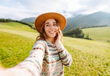 Doğada selfie çeken güzel bir genç kadın. Yaşam tarzı, seyahat, turizm, doğa, aktif yaşam.