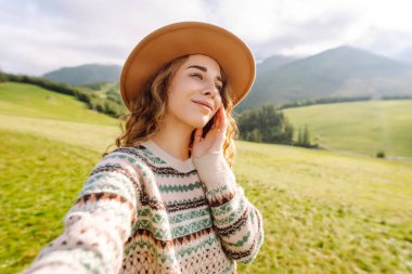 Doğada selfie çeken güzel bir genç kadın. Yaşam tarzı, seyahat, turizm, doğa, aktif yaşam.