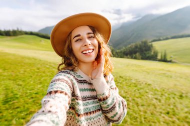 Doğada selfie çeken güzel bir genç kadın. Yaşam tarzı, seyahat, turizm, doğa, aktif yaşam.