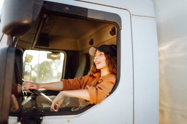 Kamyon camından dışarı bakan kadın sürücü. Ulaştırma sektörü teması