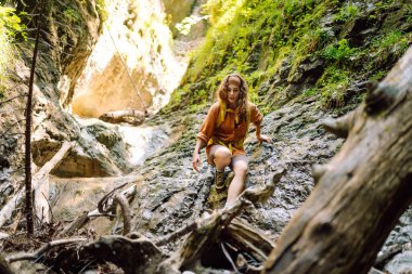 Bir mağara turistinde gezgin kadın turist macerası. Sırt çantalı genç bir kadın dışarı çıkıyor. Yürüyüş, aktif yaşam tarzı.