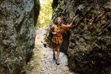 Bir mağara turistinde gezgin kadın turist macerası. Sırt çantalı genç bir kadın dışarı çıkıyor. Yürüyüş, aktif yaşam tarzı.