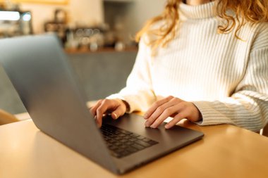 Dizüstü bilgisayarda klavye üzerinde çalışan ellerin yakın çekimi. Ev işi ve rahat bir atmosferde gezinme konsepti. Serbest, çevrimiçi kurs. İnternetten alışveriş. Siber güvenlik kavramı