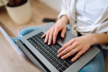 Dizüstü bilgisayarda klavye üzerinde çalışan ellerin yakın çekimi. İnternet ve modern kablosuz teknolojileri kullanma kavramı. Siber güvenlik kavramı