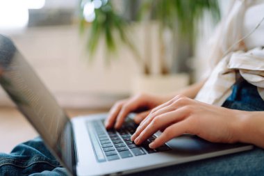 Dizüstü bilgisayarda klavye üzerinde çalışan ellerin yakın çekimi. İnternet ve modern kablosuz teknolojileri kullanma kavramı. Siber güvenlik kavramı