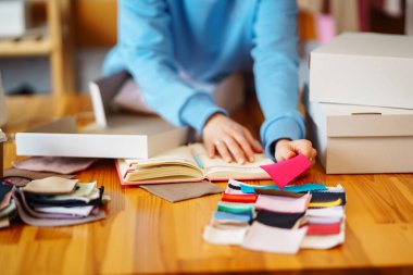 Çok renkli kumaş örneklerinin kataloğu. Çeşitli renkli örneklerden döşeme kumaşı rengi ve dokusu seçiliyor. Online mağaza, e-ticaret. Çevrimiçi satış.