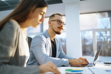 Bilgisayarda çalışan genç iş arkadaşları. Planlama, iş, öğrenim, takım çalışmasında işbirliği.