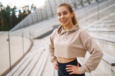 Sporcu kadın dışarıda antrenman yapıyor, esneme hareketleri yapıyor. Spor, aktif yaşam, spor eğitimi, sağlıklı yaşam tarzı..