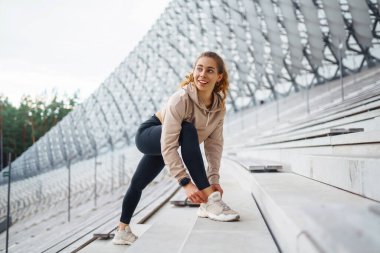 Sporcu kadın dışarıda antrenman yapıyor, esneme hareketleri yapıyor. Spor, aktif yaşam, spor eğitimi, sağlıklı yaşam tarzı..