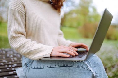 Genç bir kadın açık havada çalışıyor ve lanet parkın güzel havasının tadını çıkarıyor. Bağımsızlık, teknoloji, eğitim, iş dünyası, blog konsepti.