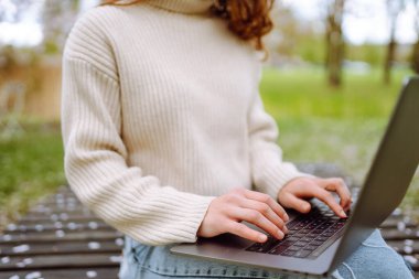 Genç bir kadın açık havada çalışıyor ve lanet parkın güzel havasının tadını çıkarıyor. Bağımsızlık, teknoloji, eğitim, iş dünyası, blog konsepti.