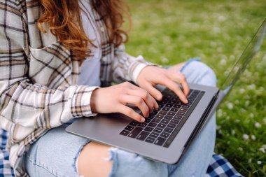 Genç bir kadın açık havada çalışıyor ve lanet parkın güzel havasının tadını çıkarıyor. Bağımsızlık, teknoloji, eğitim, iş dünyası, blog konsepti.