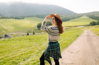 Güneşli yaz gününde tarlada yürüyen güzel bir kadın. Doğa, tatil, rahatlama ve yaşam tarzı. Yaz manzarası.