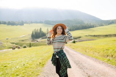 Güneşli yaz gününde tarlada yürüyen güzel bir kadın. Doğa, tatil, rahatlama ve yaşam tarzı. Yaz manzarası.