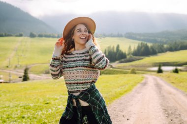 Güneşli yaz gününde tarlada yürüyen güzel bir kadın. Doğa, tatil, rahatlama ve yaşam tarzı. Yaz manzarası.