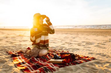Plajda sabah kahvesi içen genç bir kadın. Seyahat, hafta sonu, rahatlama ve yaşam tarzı konsepti.