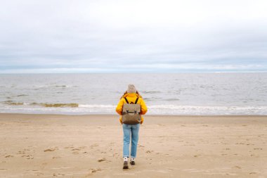 Kış plajında güzel bir kadın. Soğuk hava. Seyahat, yaşam tarzı, macera.