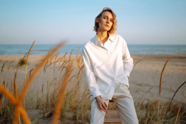 Deniz kenarında yürüyen çekici bir kadın. Moda, güzellik konsepti.