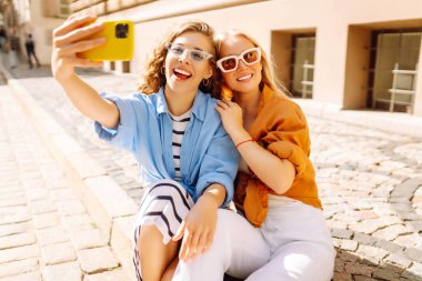 Genç arkadaşlar eğleniyor ve telefonda selfie çekiyorlar. Yaşam tarzı, eğlence, eğlence, gençlik kavramı.
