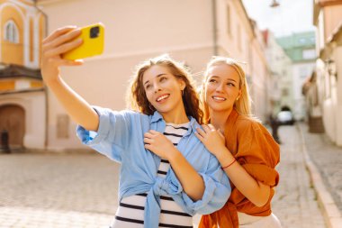 Genç arkadaşlar eğleniyor ve telefonda selfie çekiyorlar. Yaşam tarzı, eğlence, eğlence, gençlik kavramı.